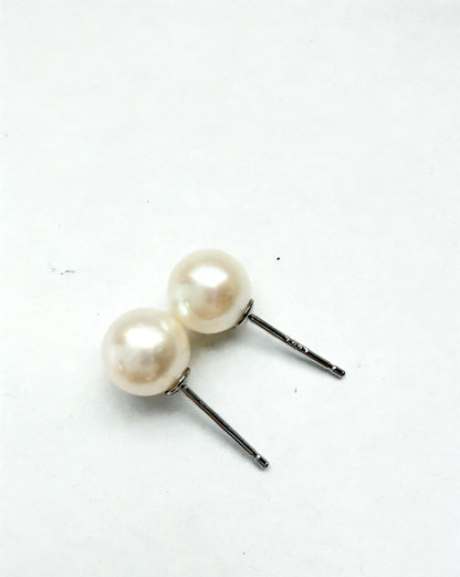 Two 7mm white freshwater pearl stud earrings with sterling silver posts on a white background.