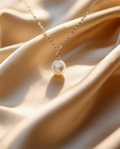 Luvymia 7mm Hepu saltwater pearl pendant necklace with a silver chain on gold satin.