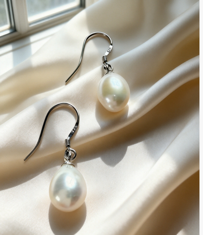 Baroque freshwater pearl drop earrings with 925 sterling silver hooks on cream silk.