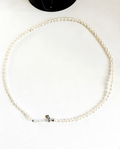 Minimalist baroque freshwater pearl necklace with 3-4mm seed pearls and 925 sterling silver clasp.