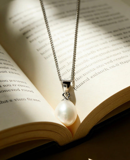 Luvymia baroque freshwater pearl pendant necklace with a 925 sterling silver chain on an open book.