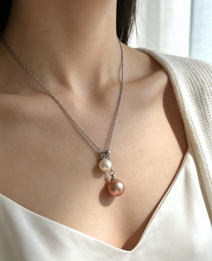 Double freshwater pearl pendant necklace with 6-7mm peach pink and 4-5mm white pearls on a sterling silver chain.