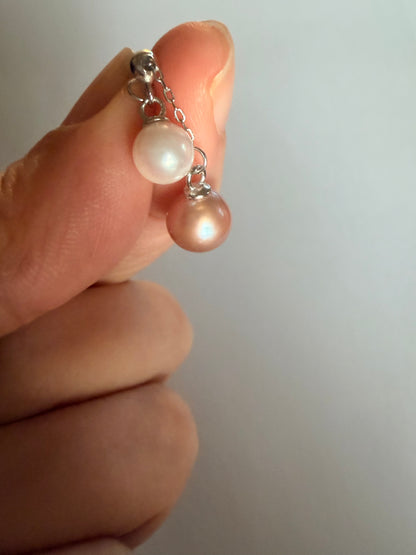 Hand holding a Luvymia double freshwater pearl pendant necklace with peach pink and white pearls on sterling silver.