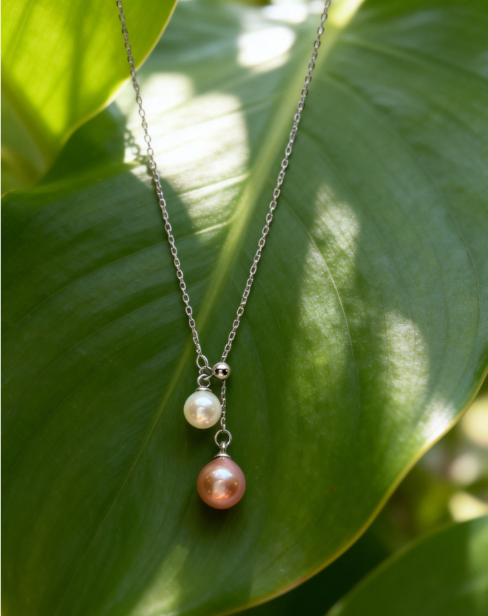 925 sterling silver necklace with a peach pink 6-7mm and white 4-5mm double freshwater pearl pendant on a green leaf.