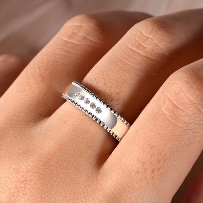 Men's wide S925 silver moissanite wedding ring with beaded edges and five D-color VVS1 stones.