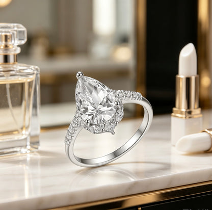 8x12mm pear-cut D color moissanite halo ring with marquise and pavé accents on S925 silver.